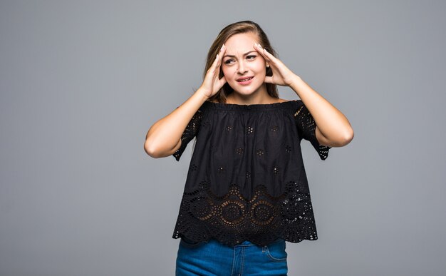 Zich moe en gespannen voelen. Gefrustreerde jonge vrouw die oren bedekt met handen op grijs