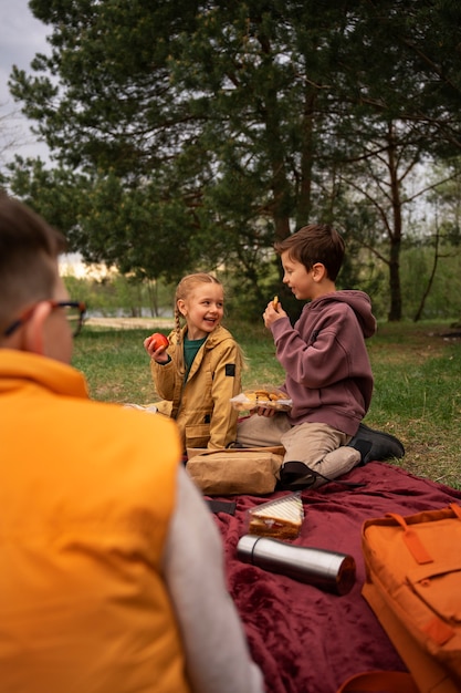 Gratis foto zicht op kleine kinderen met rugzakken die buiten tijd doorbrengen in de natuur