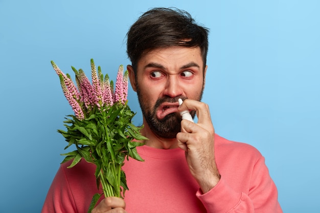 Zieke jonge man die lijdt aan allergie geïsoleerd