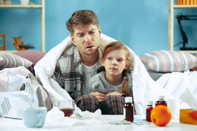 Zieke man met dochter thuis. Thuisbehandeling. Vechten met een ziekte. Medische gezondheidszorg.