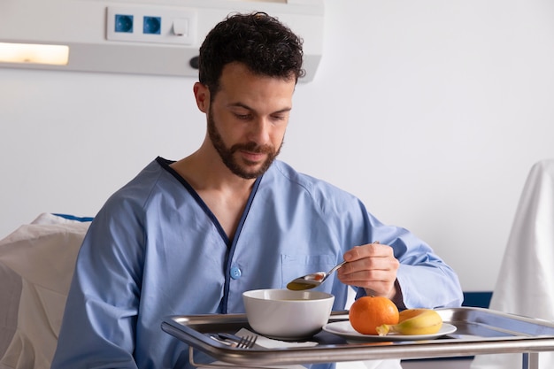 Zieke mannelijke patiënt in bed in het ziekenhuis