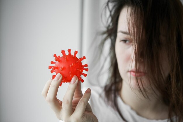 Ziekte jonge vrouw met rood virus vast zieke vrouw met symbool van coronavirus