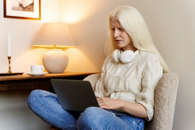 Zijaanzicht albino vrouw die op laptop werkt