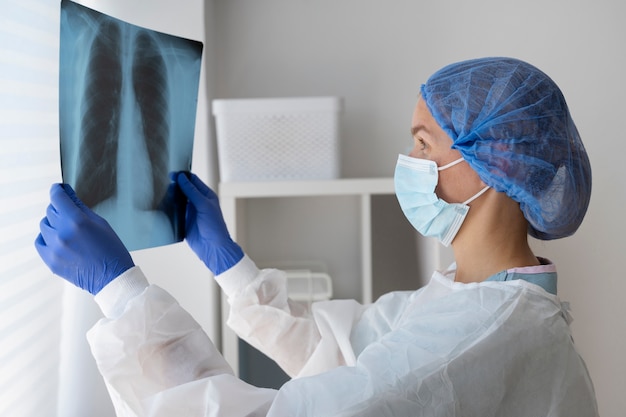 Gratis foto zijaanzicht arts die radiografie controleert