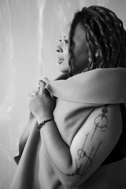 Gratis foto zijaanzicht authentieke vrouw met tatoeages