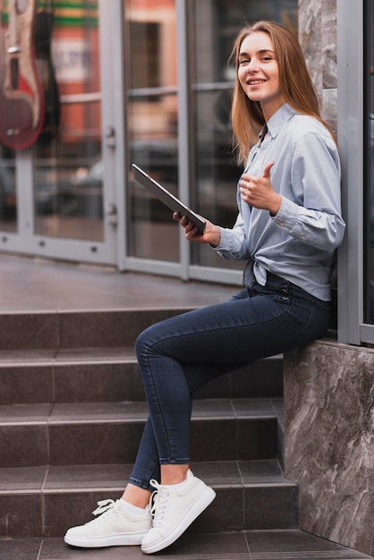 Zijaanzicht blonde meisje met een tablet