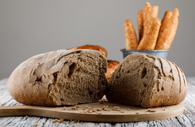 Zijaanzicht brood verdeeld in de helft op snijplank met Turkse bagel op houten oppervlak. horizontaal