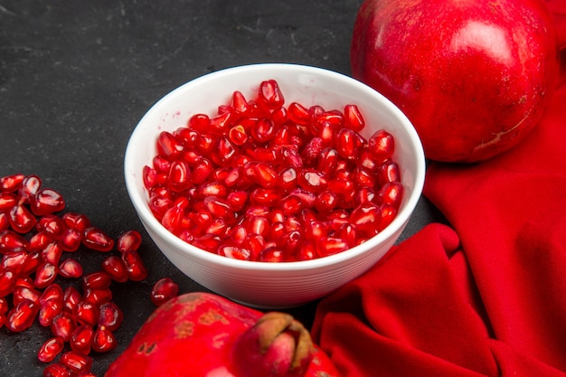 Zijaanzicht close-up granaatappel rood tafelkleed granaatappels kom met granaatappelpitten