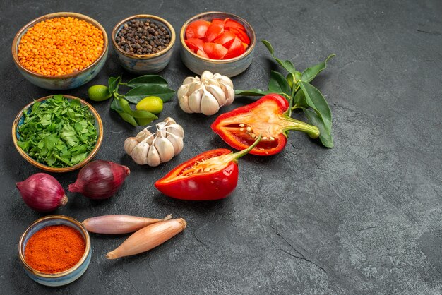 Zijaanzicht close-up groenten kom linze knoflook kruiden ui kruiden tomaten paprika