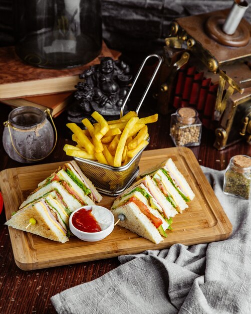 Zijaanzicht club sandwich met frietjes en ketchup met mayonaise