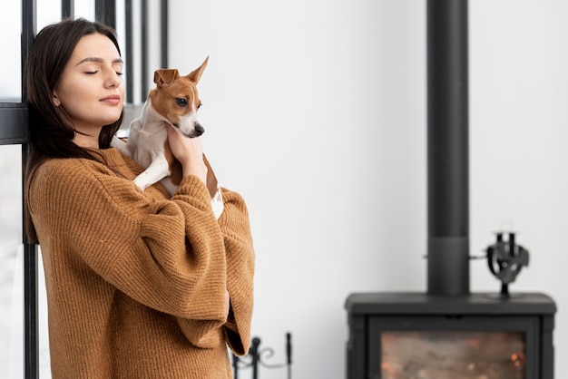 Gratis foto zijaanzicht dat van vrouw haar hond houdt