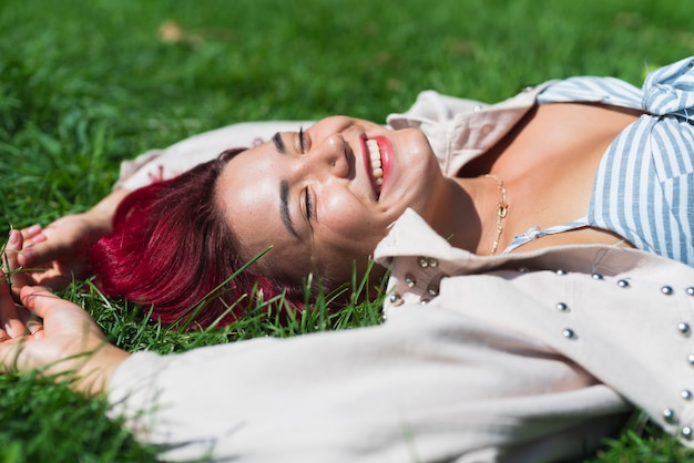 Zijaanzicht dat van vrouw in gras ligt