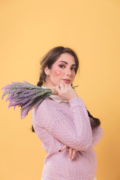 Zijaanzicht dat van vrouw terwijl het houden van lavendel stelt