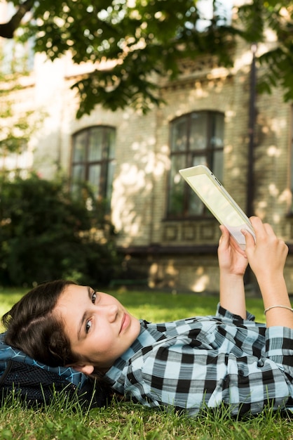 Zijaanzicht dichte omhooggaand van schoolmeisje die tablet gebruiken