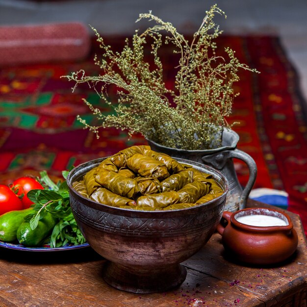 Zijaanzicht dolma met verse groenten en yoghurt in koperen diepe plaat