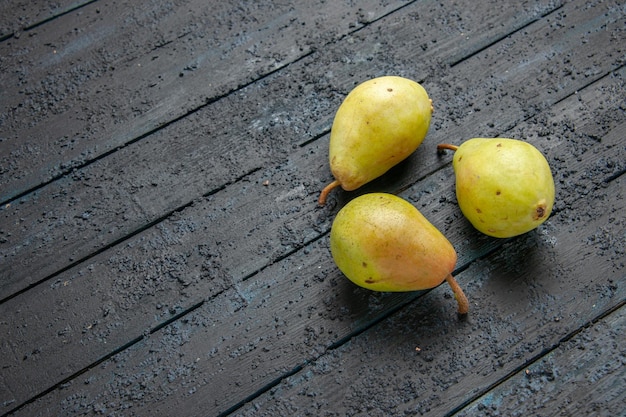 Zijaanzicht drie peren drie groene peren zijn opgemaakt in een cirkel op een grijze achtergrond