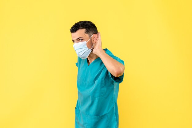 Zijaanzicht een dokter in masker een dokter luistert naar klachten van coronaviruspatiënten