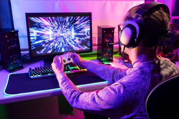 Gratis foto zijaanzicht gamer die binnen speelt