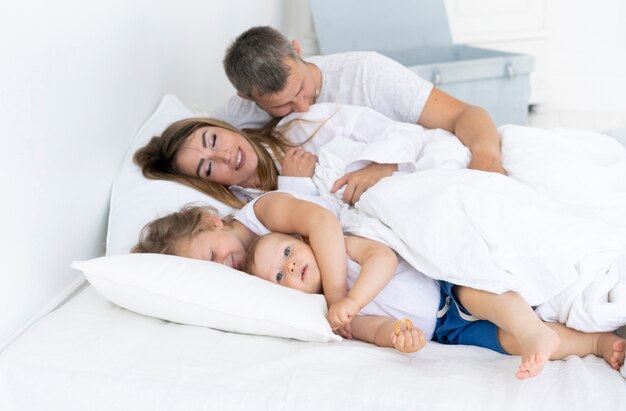 Zijaanzicht gelukkige familie die in bed legt