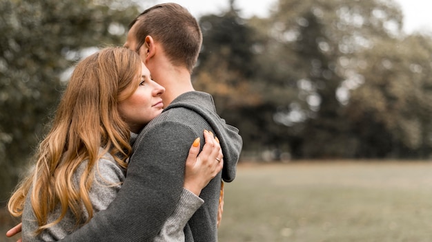 Gratis foto zijaanzicht gelukkige partners knuffelen