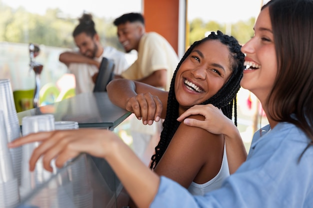 Gratis foto zijaanzicht gelukkige vrouwen op foodfestival