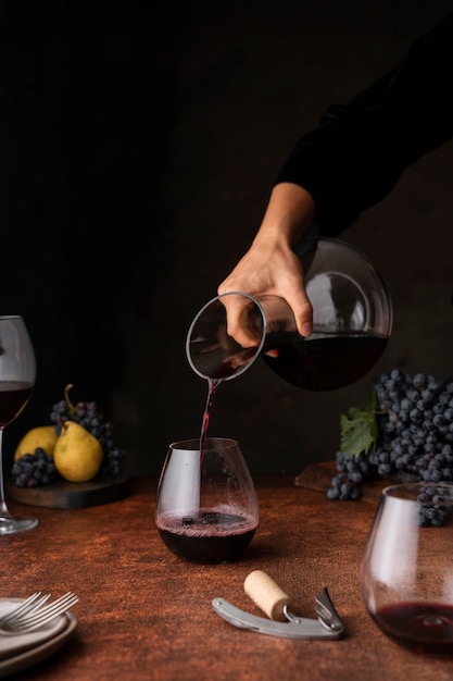 Gratis foto zijaanzicht hand schenkende wijn