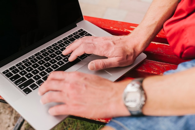 Zijaanzicht handen op laptop toetsenbord