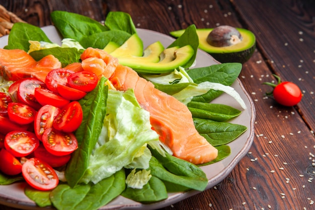 Zijaanzicht heerlijke maaltijd in plaat met avocado op houten achtergrond.