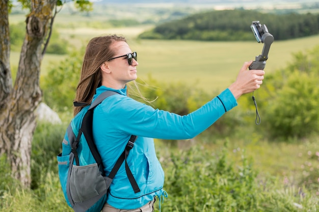 Zijaanzicht jonge reiziger die een selfie in openlucht neemt