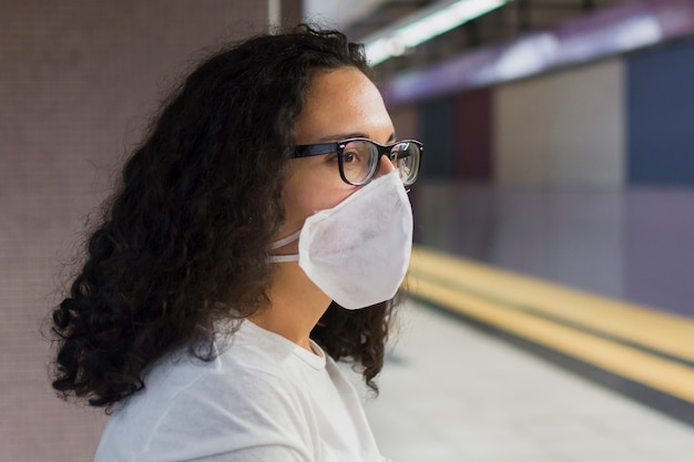 Zijaanzicht jonge vrouw met medisch maskerwachten