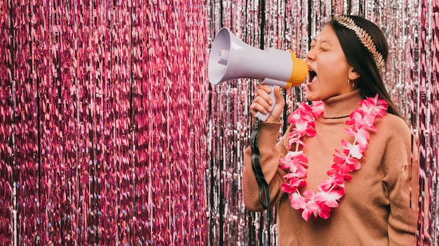 Zijaanzicht jonge vrouw met megafoon op carnaval feest