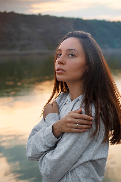 Gratis foto zijaanzicht jonge vrouw poseren buiten