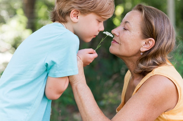 Gratis foto zijaanzicht jongen bedrijf bloem