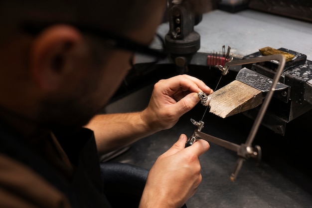 Gratis foto zijaanzicht juwelier die sieraden maakt