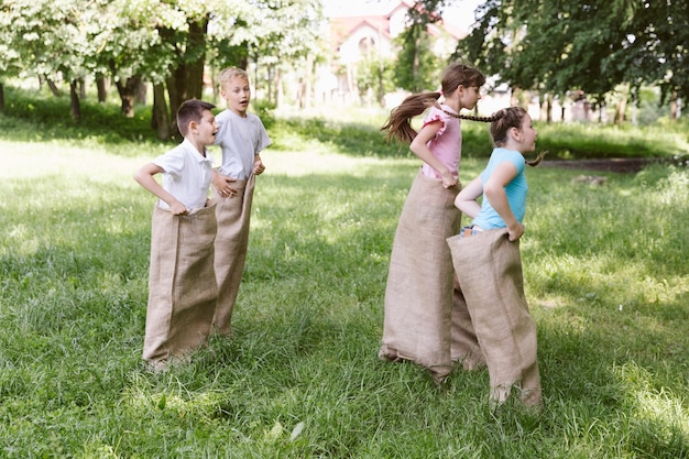 Zijaanzicht kinderen spelen in jute zakken