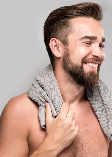 Gratis foto zijaanzicht knappe shirtless man die lacht