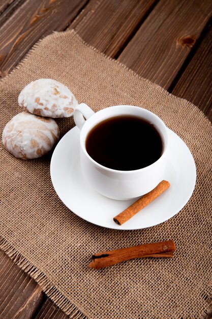 zijaanzicht Kopje koffie met kaneel en peperkoek op houten tafel