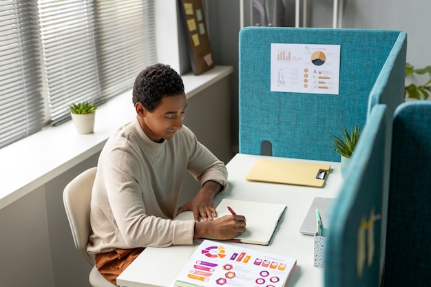 Gratis foto zijaanzicht man aan het werk aan bureau