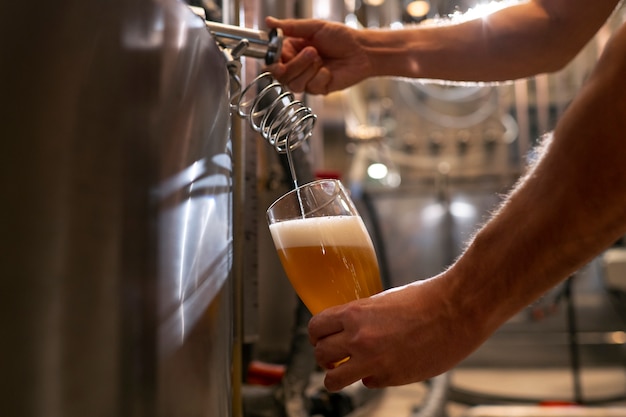 Gratis foto zijaanzicht man aan het werk in de bierfabriek