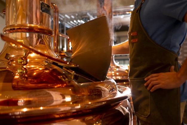 Gratis foto zijaanzicht man aan het werk in de bierfabriek