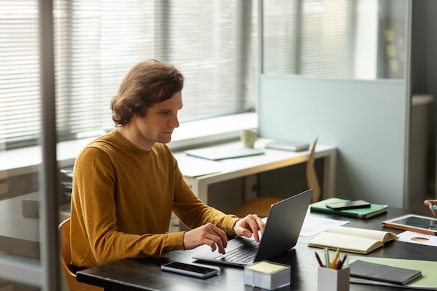 Zijaanzicht man aan het werk op laptop