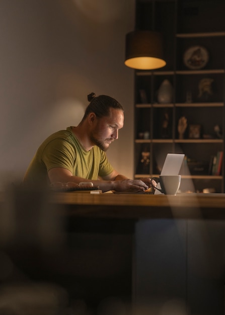 Zijaanzicht man aan het werk 's avonds laat