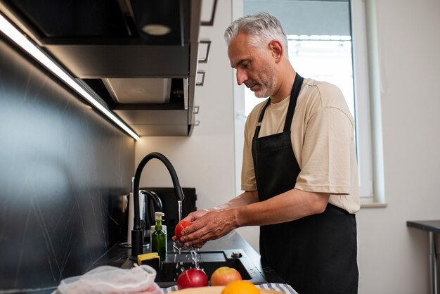 Zijaanzicht man die fruit wast