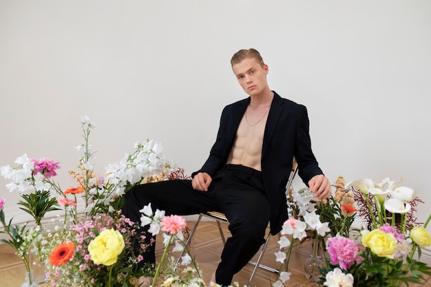 Gratis foto zijaanzicht man poseren met bloemen