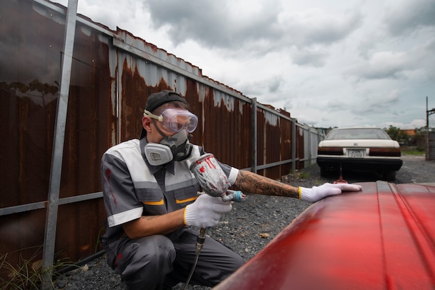 Gratis foto zijaanzicht man schilderij autodeur