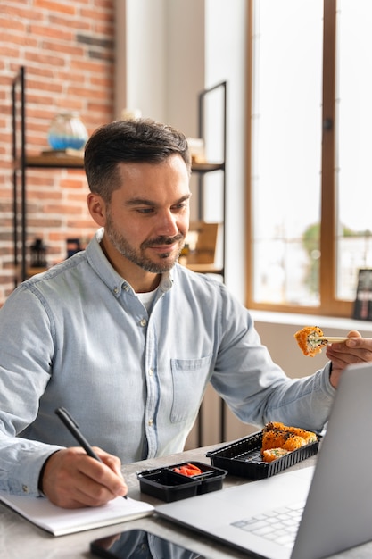 Zijaanzicht man sushi eten en werken