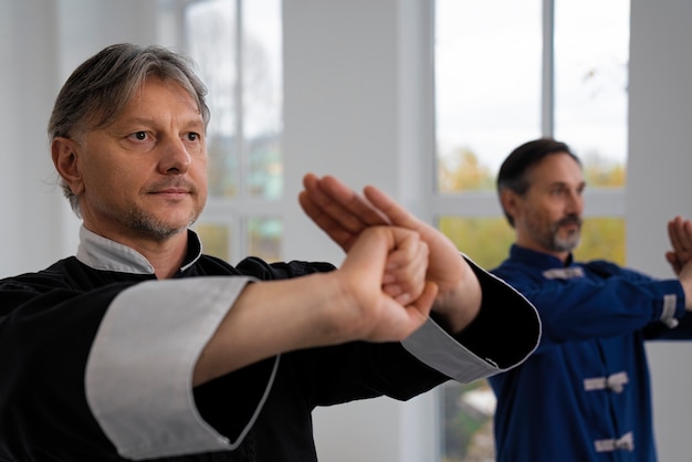 Gratis foto zijaanzicht mannen die tai chi beoefenen