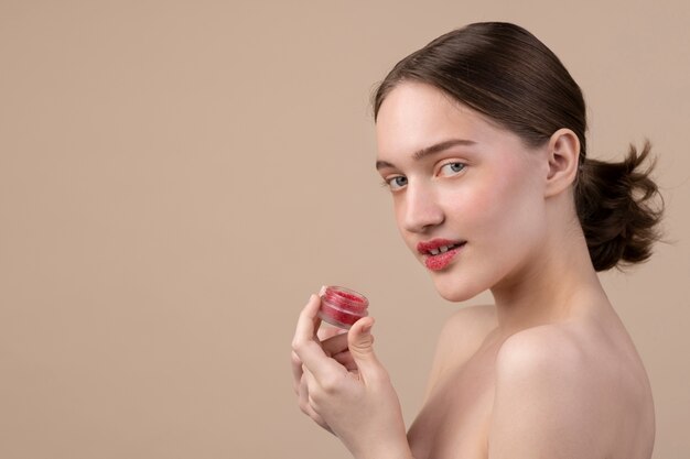 Zijaanzicht meisje poseren met lip scrub