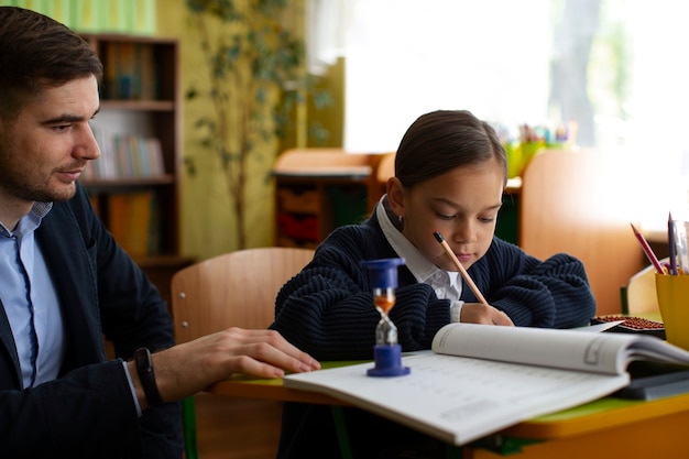 Gratis foto zijaanzicht meisje wiskunde leren op school