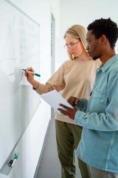 Gratis foto zijaanzicht mensen die wiskunde studeren